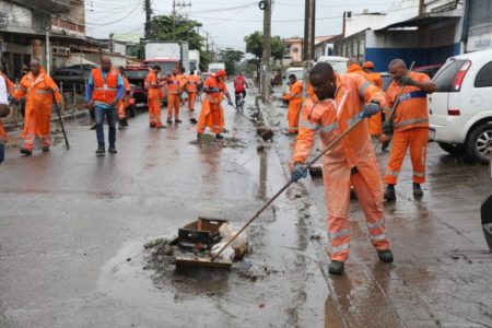 imagem colorida mostra agentes limpando rua após chuva intensa no Rio de Janeiro - Metrópoles