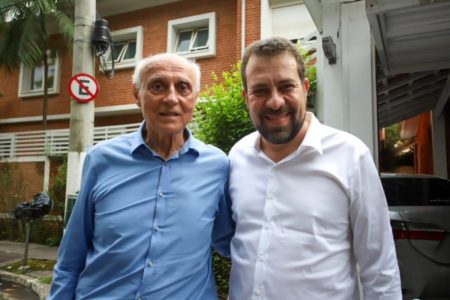 Imagem colorida mostra Edurdo Suplicy, branco idoso de camisa azul, e Guilherme Boulos, branco de cabelo e barba castanhos e camisa branca, posando para foto - Metrópoles