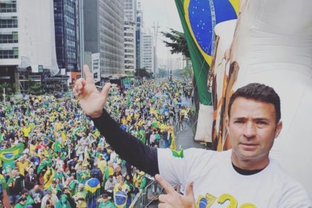 Imagem colorida mostra Mello Araujo fazendo gesto bolsonarista de armas com as mãos - Metrópoles