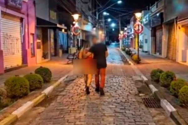 Reprodução de frame de vídeo. Imagem mostra casal, de costas, andando abraçado - Metrópoles