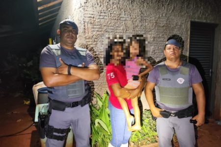 Imagem colorida mostra policiais militares (PM) com uma mulher e uma criança entre eles; a menina foi resgatada no meio da mata após sair correndo em uma distração da avó