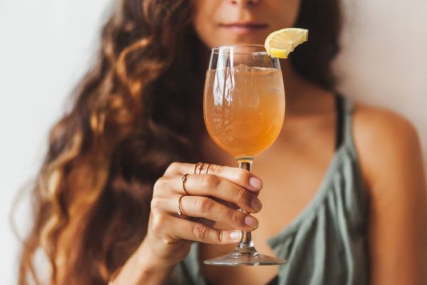 mulher segurando um drink alaranjado