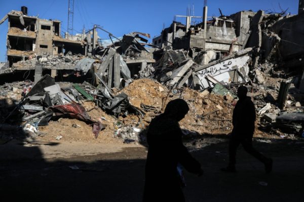 Palestinos choram em frente a um prédio destruído no campo de Al-Maghazi, na Faixa de Gaza, em 30 de novembro de 2023 - Metrópoles