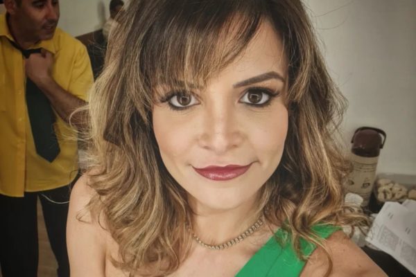 Renata Del Bianco posa, de blusa verde, nos bastidores do SBT - Metrópoles