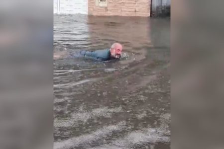 Homem nada em rua no Jardim Progresso, no Guarujá