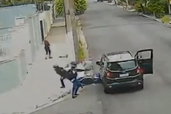 Imagem colorida mostra carro preto derrubando dois bandidos em uma moto em São Paulo - Metrópoles