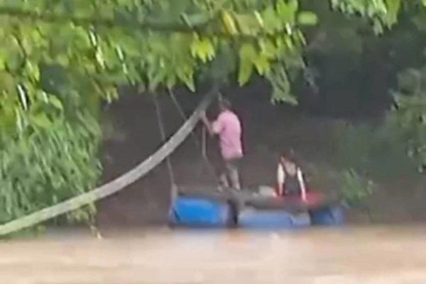 imagem colorida pai e filha atravessam rio de balsa crixas