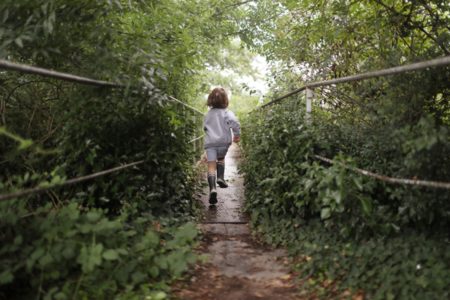 Menino correndo em poste na natureza - Metrópoles