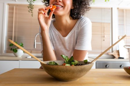 Foto colorida de uma mulher comendo -Metrópoles