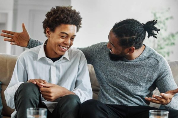 Imagem colorida de pai e filhos conversando en quanto riem