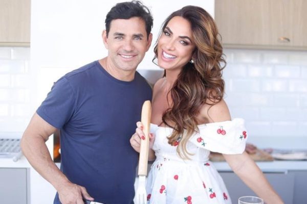 Marcelo Chagas e Nicole Bahls posam juntos e sorridentes na cozinha - Metrópoles