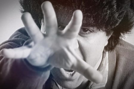 Pedro Almodóvar em foto preto e branco, escondendo o rosto com a mão - Metrópoles