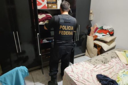 Imagem de policial federal dentro de quarto, olhando para guarda roupas - Metrópoles