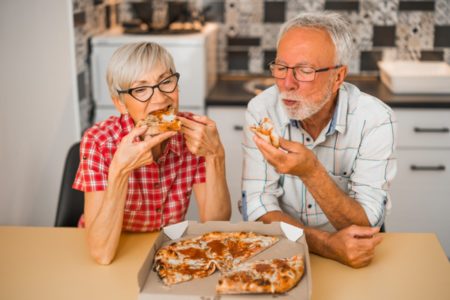 Casal de idosos comendo pizza - Metrópoles