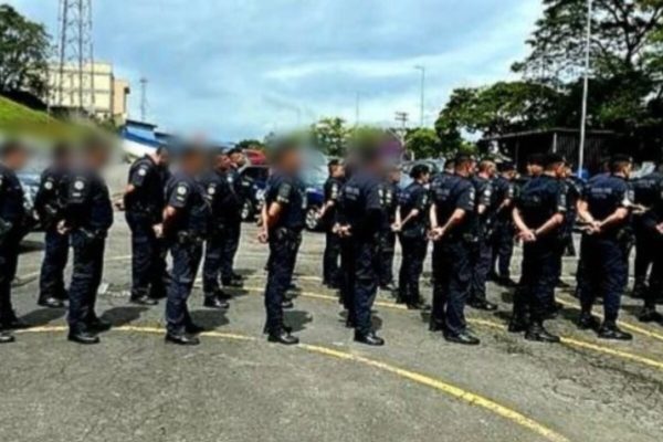 Foto colorida de pelotão de GCMs em fila e com as mãos para trás