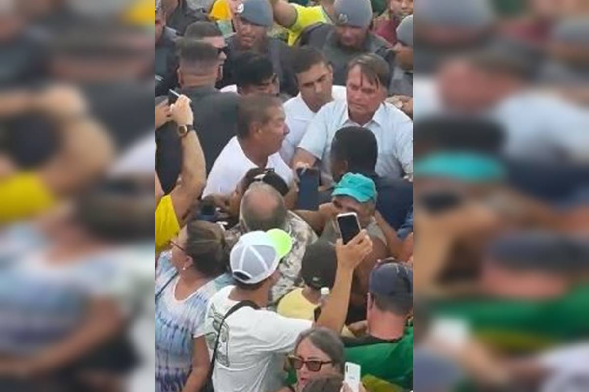 Fotografia colorida de multidão ao redor do ex-presidente Jair Bolsonaro