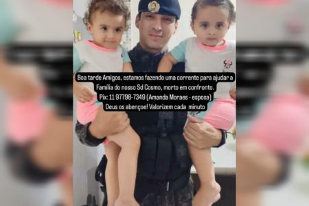Imagem de policial segurando duas meninas gêmeas nos braços - Metrópoles