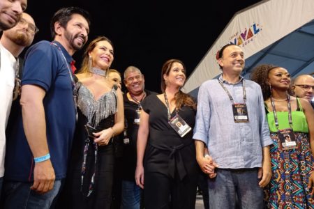 Imagem colorida mostra o prefeito Ricardo Nunes, de camisa azul, ao lado da mulher e outros convidados no Sambódromo do Anhembi, em São Paulo - Metrópoles