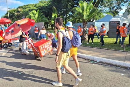 Dois homens caminham sem camisa em avenida - Metrópoles