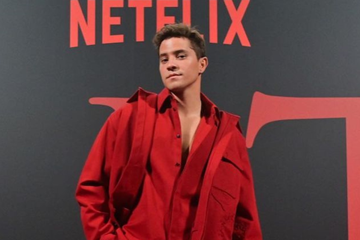 André Lamoglia posa em um dos eventos da Netflix, com um look vermelho - Metrópoles