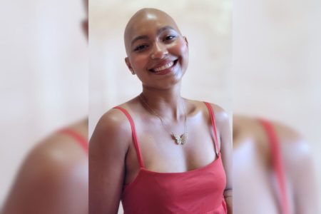 Imagem colorida de mulher de vestido sorrindo para foto - Metrópoles