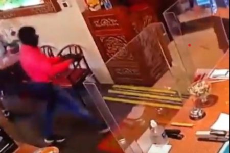 Imagem colorida mostra homem usando capuz entrando em restaurante - Metrópoles