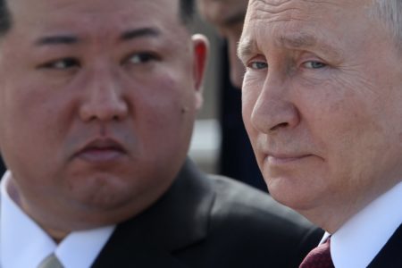 Imagem colorida mostra Putin perfilado com Kim Jong-un ao fundo - Metrópoles