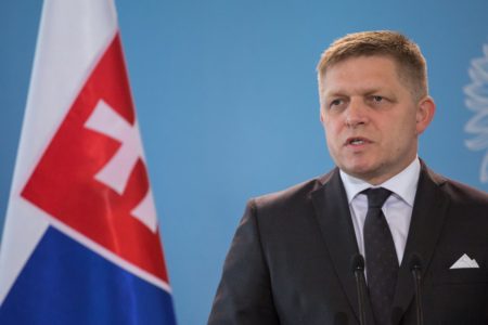 Imagem colorida mostra Robert Fico ao lado da bandeira da Eslováquia - Metrópoles