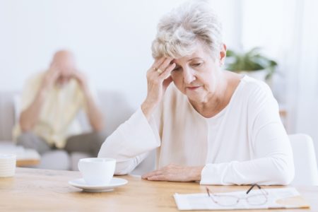 Senhora sentada com a mão na cabeça - Alzheimer