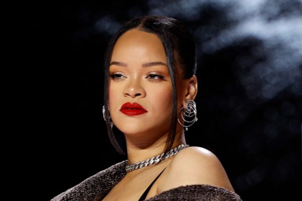 Foto colorida de Rihanna. Ela é uma mulher negra, de cabelo preto e usa batom vermelho - Metrópoles