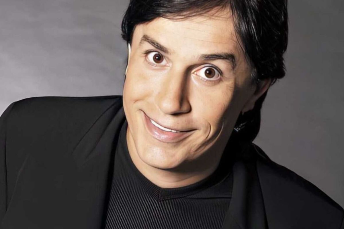 Foto colorida de Tom Cavalcante vestido de preto e sorrindo - Metrópoles