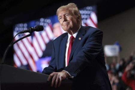 foto colorida de Donald Trump de terno azul em tribuna - metrópoles