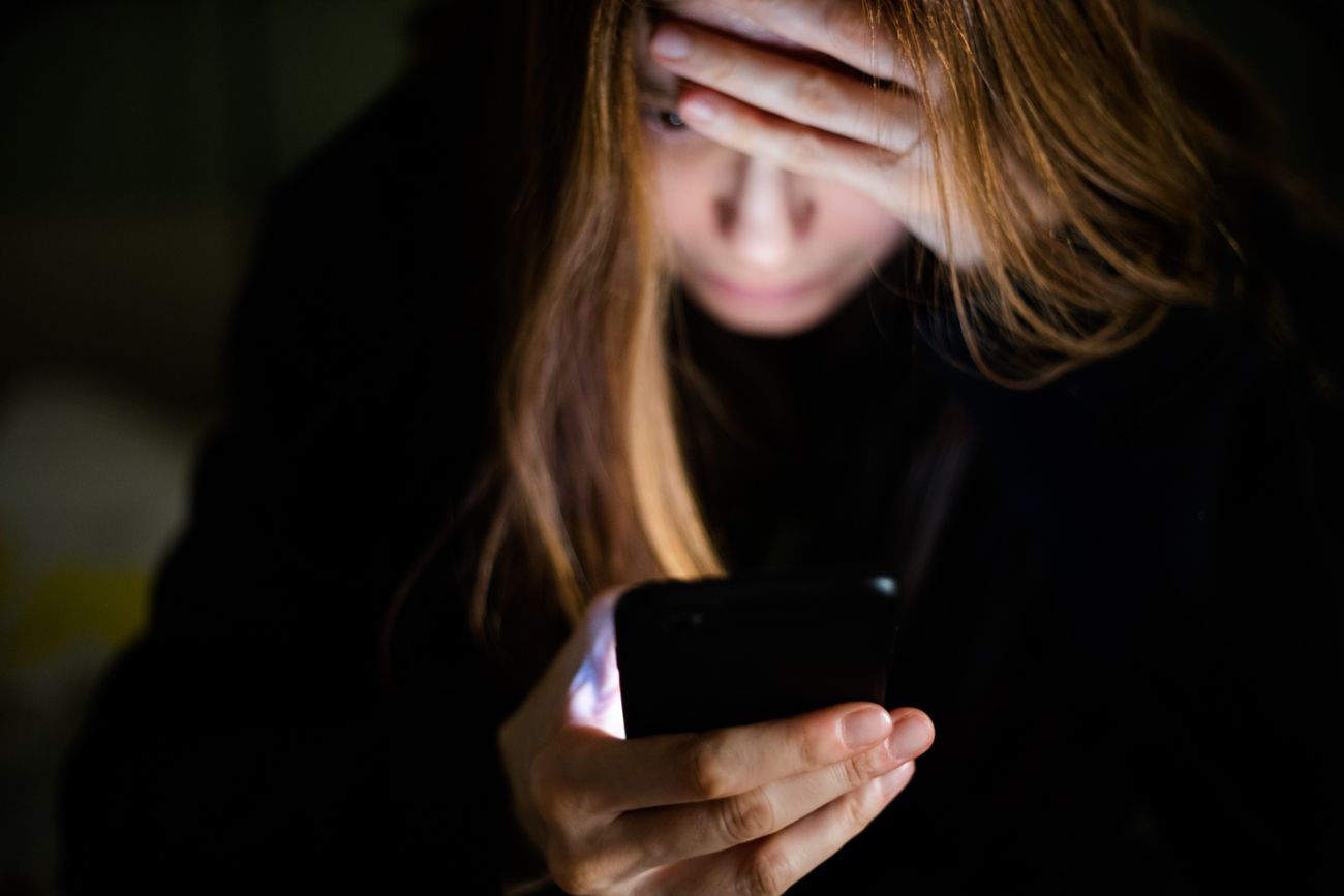 Imagem colorida de mulher assustada olhando celular; fraude empresas; golpe do Pix - Metrópoles
