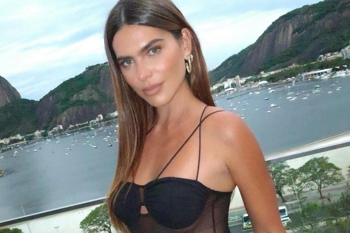 Mariana Goldfarb posa de body preto, com parte transparente, e cabelos soltos - Metrópoles