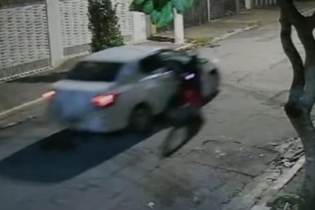 Imagem mostra carro branco arrastando uma mulher durante tentativa de assalto - Metrópoles