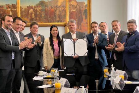 Imagem colorida mostra governador tarcísio de freitas segurando projeto de escolas cívico-militares ao lado de deputados bolsonaristas - metrópoles