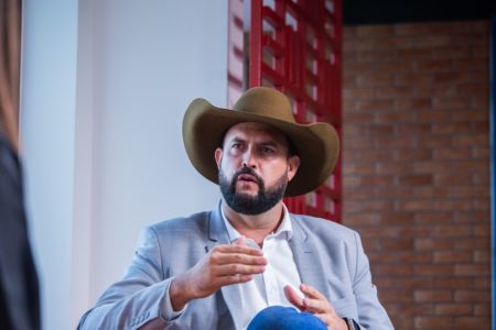 Deputado federal Zé Trovão durante entrevista ao Metrópoles, usando um chapéu e gesticulando com as mãos