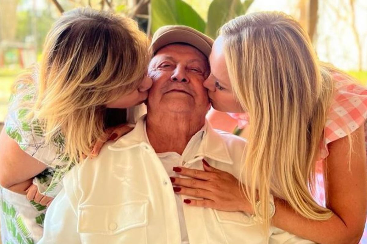 Foto colorida de Eliana dando um beijo na bochecha do pai - Metrópoles