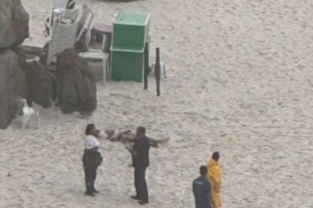 Imagem colorida de corpo de homem na areia - Metrópoles