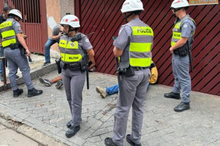 Imagem colorida de PMs detendo uma pessoa - Metrópoles