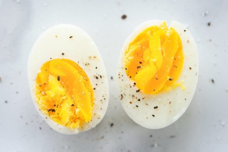 Foto mostra um ovo cozido cortado ao meio, com temperos em pó - Metrópoles