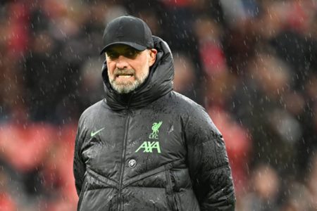 Imagem colorida de Jurgen klopp com o casaco do Liverpool em chuva - Metrópoles