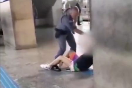 Imagem mostra homem fardado agredindo jovem caída no chão - Metrópoles