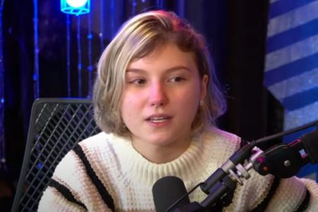 Foto colorida de Isabel Veloso em um podcast - Metrópoles