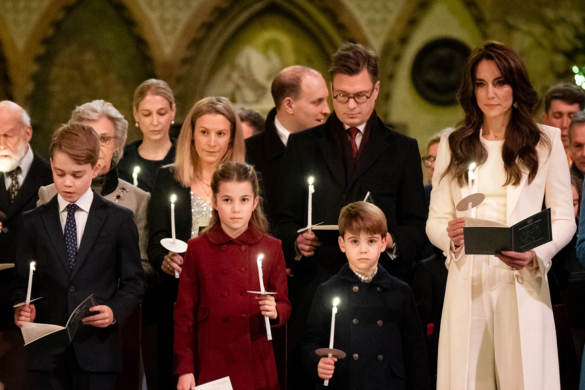 Crianças e adultos enfileirados segurando uma vela - Metrópoles