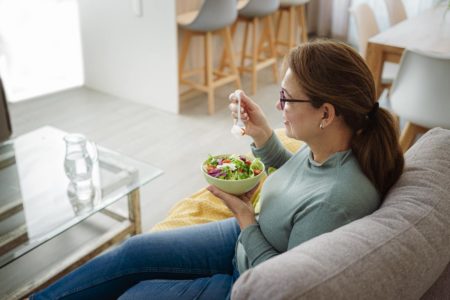 Foto colorida de uma mulher comendo - Metrópoles