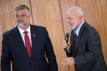 Imagem colorida de presidente Lula sorrindo e com microfone em mãos, ao lado do ministro Pimenta - Metrópoles