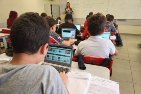 Imagem colorida mostra estudantes com computadores em sala de aula de escola estadual em São Paulo - Metrópoles