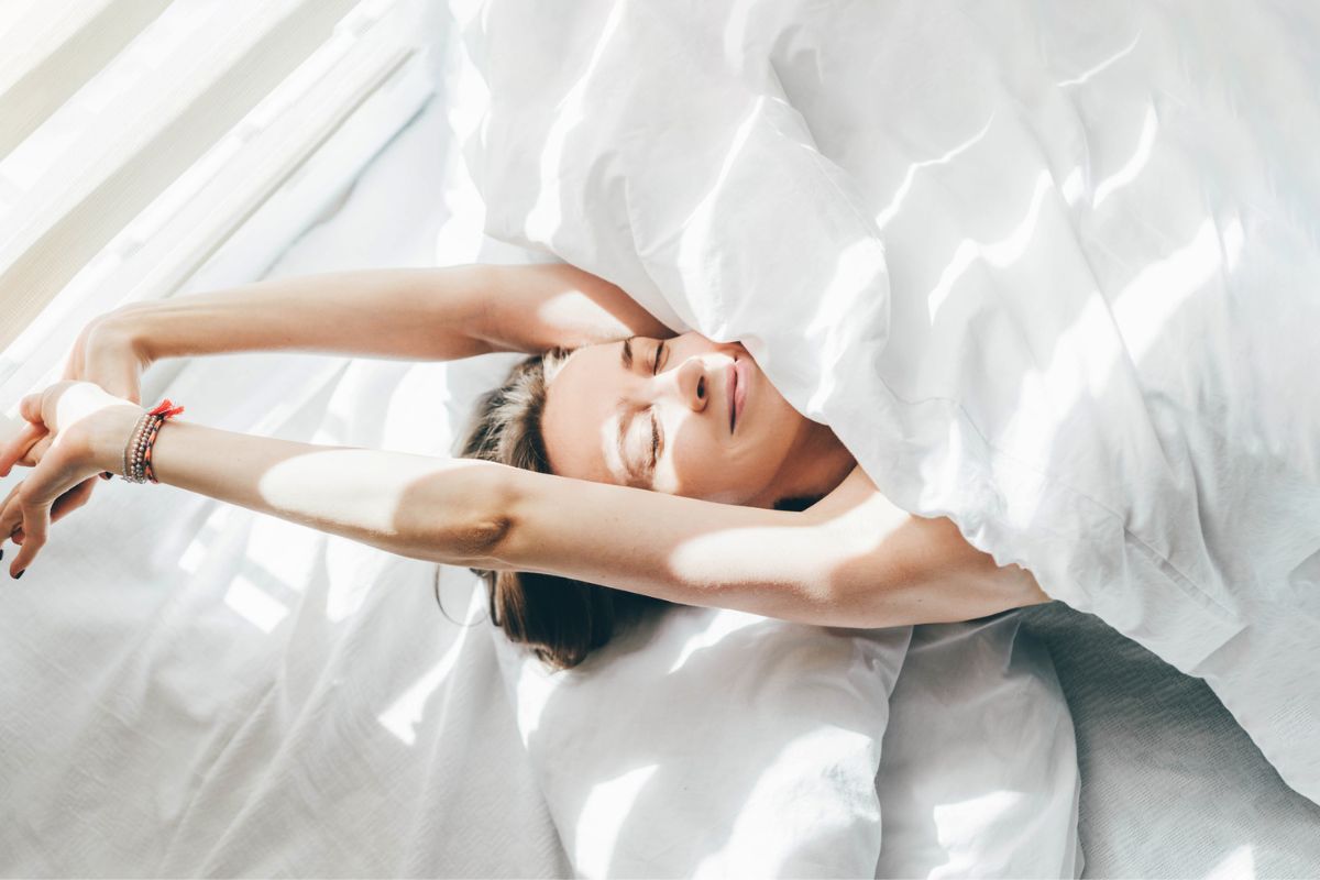 mulher espreguiçando na cama