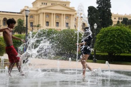 foto colorida de crianças se refrescando no chafariz do Parque da Independência em dia de forte calor em São Paulo - Metrópoles
